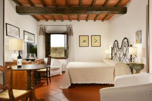 蒙特里久尼蒙特里基欧尼浪漫酒店的卧室配有一张床和一张桌子及椅子