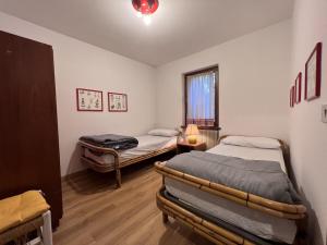 平佐洛Appartamenti Residenza Alpina的客房设有两张床和窗户。