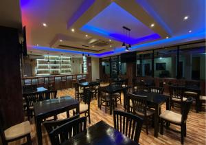 San LuisHotel y Restaurante Maria Ofelia的餐厅设有桌椅和紫色灯