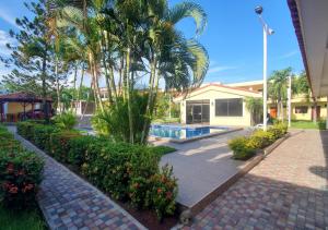 San LuisHotel y Restaurante Maria Ofelia的一座带游泳池和棕榈树的房子