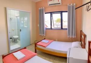 陶巴特Poupahotel的一间带两张床的卧室和一间带淋浴的浴室