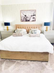 奥本Kenavara House的一间卧室配有一张带两盏灯的大型白色床。