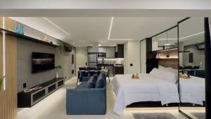 圣保罗Apartamento na paulista (com garagem)的一间卧室配有一张大床和一张蓝色的沙发