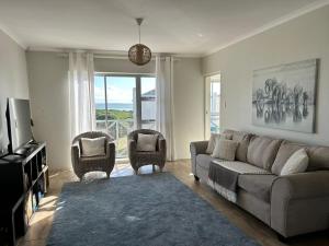 开普敦Bella Casa - Seaview-Beach Club Apartment的客厅配有沙发和两把椅子