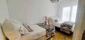 卡加尔LA CASILLA的客房设有两张床,配有斑马枕头。