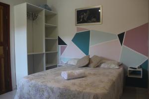 阿拉亚尔达茹达Pousada Sossego do Pirata的一间卧室配有一张带彩色墙壁的床