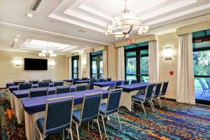 波因顿海滩博因顿海滩希尔顿恒庭旅馆&套房酒店的一间会议室,配有蓝色的桌椅和平面电视