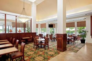 奥克布鲁克特莱斯希尔顿花园奥克布鲁克特莱斯酒店的餐厅设有桌椅和窗户。