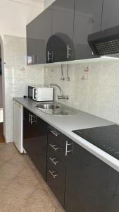 波尔蒂芒Hostel da Praia的厨房配有水槽和微波炉