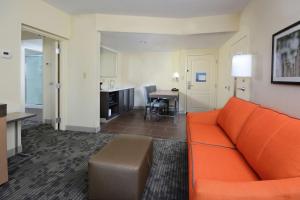 邓肯格林维尔/斯巴坦堡I-85希尔顿恒庭旅馆&套房酒店的一间带橙色沙发的客厅和一间厨房