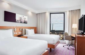 伦敦汉普顿伦敦滑铁卢希尔顿酒店的酒店客房设有两张床、一张书桌和一个窗户。