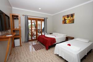 日若卡-迪热里科阿科阿拉Pousada e Restaurante Paraíso Natural的酒店客房设有两张床和电视。