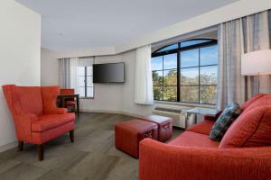 圣巴巴拉圣芭芭拉/戈勒塔希尔顿恒庭酒店的客厅配有红色家具和大窗户