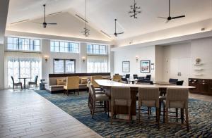 新温莎纽堡斯图尔特机场希尔顿惠庭套房酒店的大堂设有大桌子和椅子