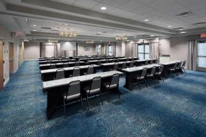 新温莎纽堡斯图尔特机场希尔顿惠庭套房酒店的一间会议室,配有桌椅和屏幕