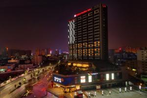 宝安深圳宝安华盛希尔顿花园酒店的一座高大的建筑,上面有红灯