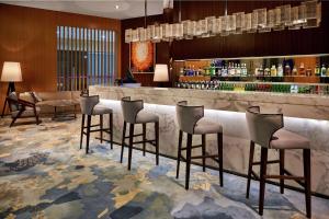 宝安深圳宝安华盛希尔顿花园酒店的一间酒吧,在旅馆房间设有四把凳子
