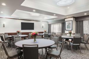 温莎洛克斯哈特福德机场汉普顿酒店的一间会议室,配有桌椅和平面电视