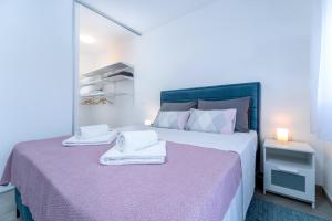 奥西耶克Sunrise & Sunset Apartmani - Self Check In的一间卧室配有一张大床和毛巾