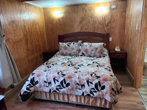 瓦尔迪维亚Hotel CasaGrande的一间卧室配有一张带花卉棉被的床