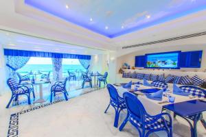 亚历山大Hilton Alexandria Corniche Hotel的一间配备有蓝色椅子和桌子的用餐室