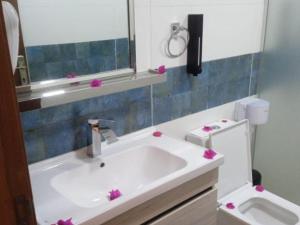 亚喀巴Wadi Rum Gulf camp的浴室设有水槽和粉红色鲜花的卫生间。