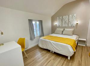 勒布尔热Le Cocon - logement 4 personnes - Neuf - Wifi的一间卧室配有一张黄色毯子床