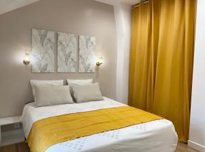勒布尔热Le Cocon - logement 4 personnes - Neuf - Wifi的一间卧室配有一张黄色窗帘的床