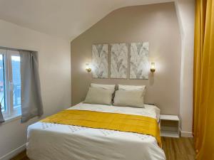 勒布尔热Le Cocon - logement 4 personnes - Neuf - Wifi的一间卧室配有一张黄色毯子床