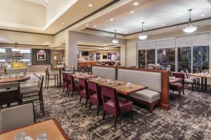 布莱克斯堡Hilton Garden Inn Blacksburg University的一间带桌椅的餐厅和一间酒吧