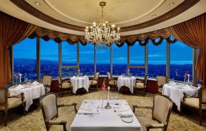 贝鲁特贝鲁特哈卜图希尔顿大酒店的一间带桌椅和吊灯的用餐室