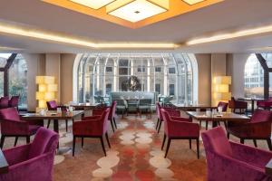 柏林希尔顿柏林酒店的餐厅设有桌椅和大窗户。