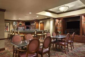 哥伦比亚Embassy Suites by Hilton Columbia Greystone的餐厅设有桌椅和平面电视。