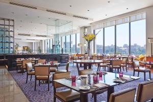 开罗开罗克拉德酒店和赌场的餐厅设有桌椅和大窗户。
