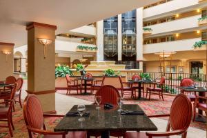 哥伦比亚Embassy Suites by Hilton Columbia Greystone的庭院内带桌椅的餐厅