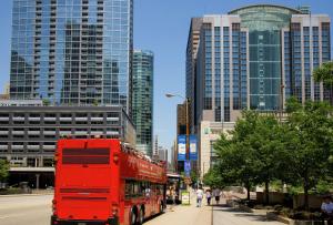 芝加哥Embassy Suites by Hilton Chicago Downtown Magnificent Mile的一辆红色双层巴士沿着城市街道行驶