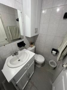 AtuntaquiHermoso y acogedor departamento的白色的浴室设有水槽和卫生间。