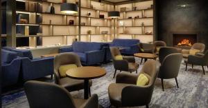 柯罗格伦都柏林机场希尔顿酒店的一间设有蓝色桌椅和壁炉的等候室