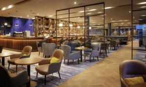 柯罗格伦都柏林机场希尔顿酒店的一间带桌椅的餐厅和一间酒吧