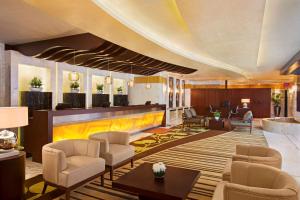 迪拜DoubleTree by Hilton Hotel and Residences Dubai – Al Barsha的大堂设有椅子和前台