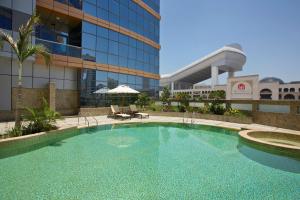迪拜DoubleTree by Hilton Hotel and Residences Dubai – Al Barsha的大楼前的大型游泳池