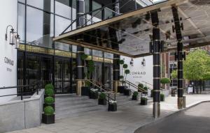 都柏林都柏林康拉德酒店的建筑的外墙,有楼梯和盆栽植物
