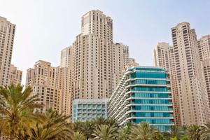 迪拜迪拜朱美拉希尔顿度假酒店的拥有高楼和棕榈树的城市天际线