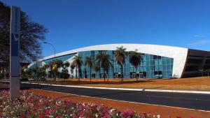 巴西利亚V320 Espaço Inteiro Wi-Fi Exclusivo Área Central的一座大型玻璃建筑,前面有棕榈树