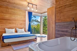 RakitovoForest Lux Boutique Villas的卧室配有床、浴缸和窗户。