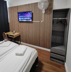 乌得勒支荷兰旅舍酒店的一间卧室配有一张床,墙上配有电视