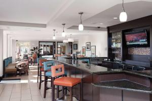 法戈法戈希尔顿花园旅馆的餐厅内的酒吧,配有桌椅