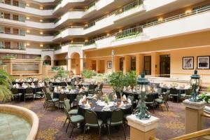 格林斯伯勒Embassy Suites by Hilton Greensboro Airport的大楼内带桌椅的宴会厅