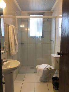佩洛塔斯Hotel Estoril的带淋浴、卫生间和盥洗盆的浴室