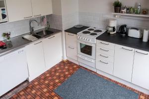 海门林纳Family apartment Hämeenlinna with SAUNA的厨房配有白色橱柜和炉灶烤箱。